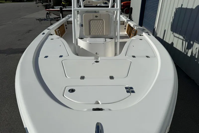 Slide: The Image of 2024 Sea Pro 210 Bay boat, white deck, spacious layout, docked outdoors. - 7