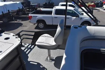 Slide: The Image of 2026 Lowe SF 212 Sport Fish boat with seating, parked near white trucks. - 23