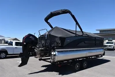 Slide: The Image of 2026 Lowe SF 212 Sport Fish pontoon boat with canopy on trailer, parked outdoors. - 3