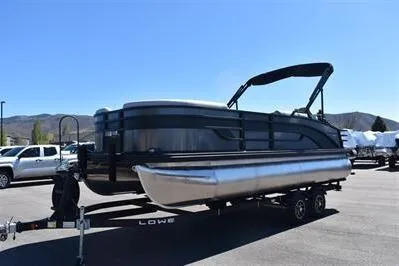 Slide: The Image of 2026 Lowe SF 212 Sport Fish pontoon boat on trailer, parked outdoors under clear blue sky. - 4