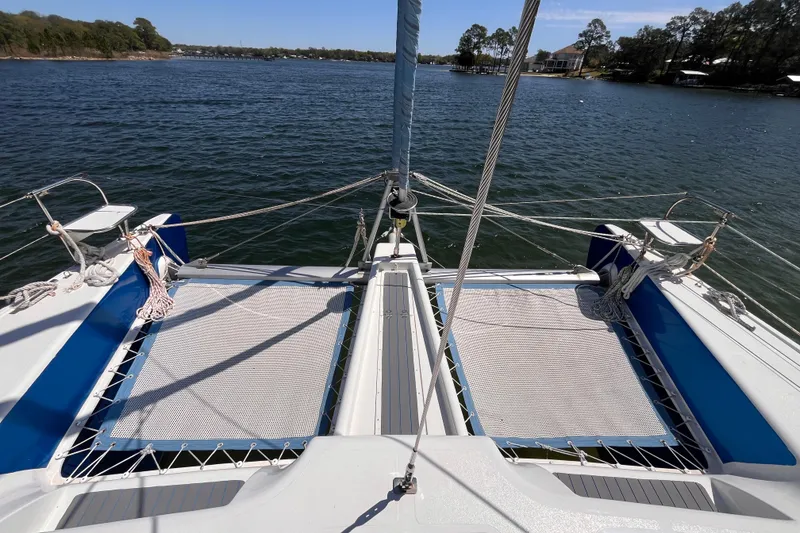 Slide: The Image of 2008 Broadblue 415 catamaran deck view, featuring netting and ropes on a serene water backdrop. - 6