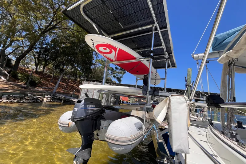 Slide: The Image of Broadblue 415 catamaran with solar panels, Yamaha outboard, and paddleboard, docked in clear water. - 69