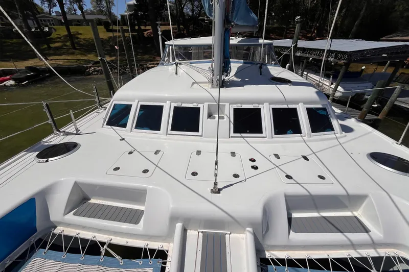 Slide: The Image of 2008 Broadblue 415 catamaran deck with windows and rigging, docked near shoreline. - 7