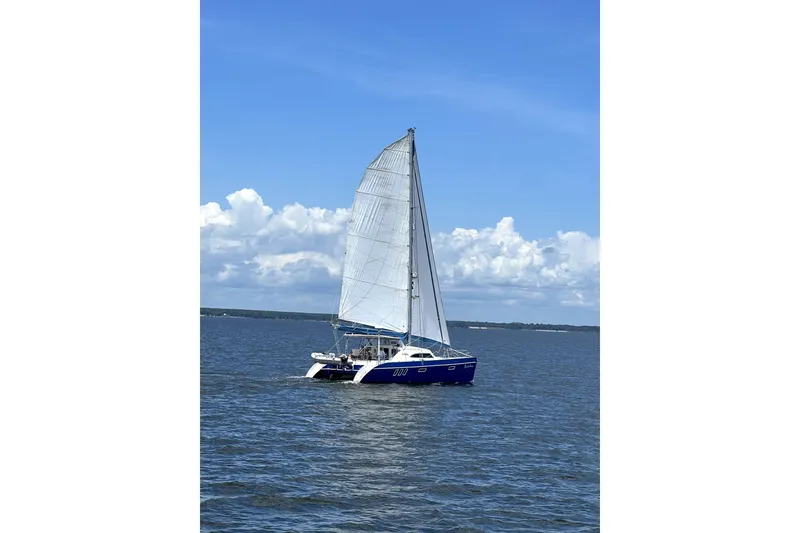 Slide: The Image of Sailing catamaran Broadblue 415 from 2008 on open water under a clear blue sky. - 82
