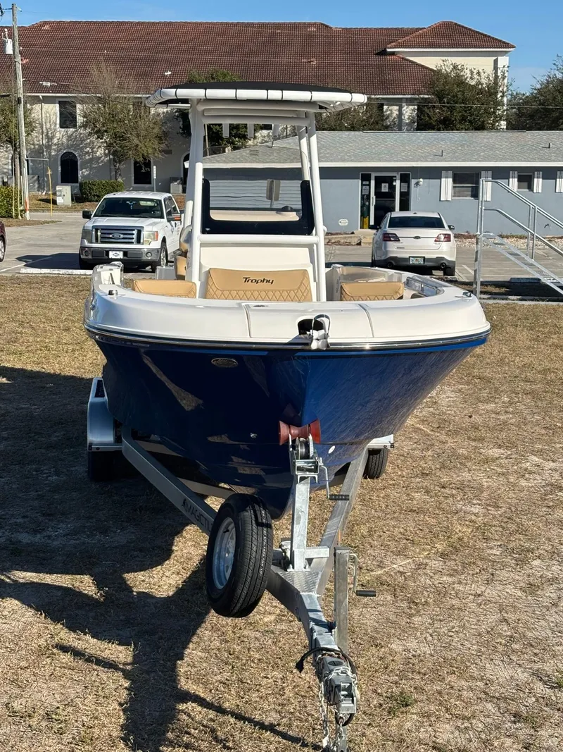 Slide: The Image of 2025 Trophy T24 CC boat on trailer, blue, parked outdoors. - 11