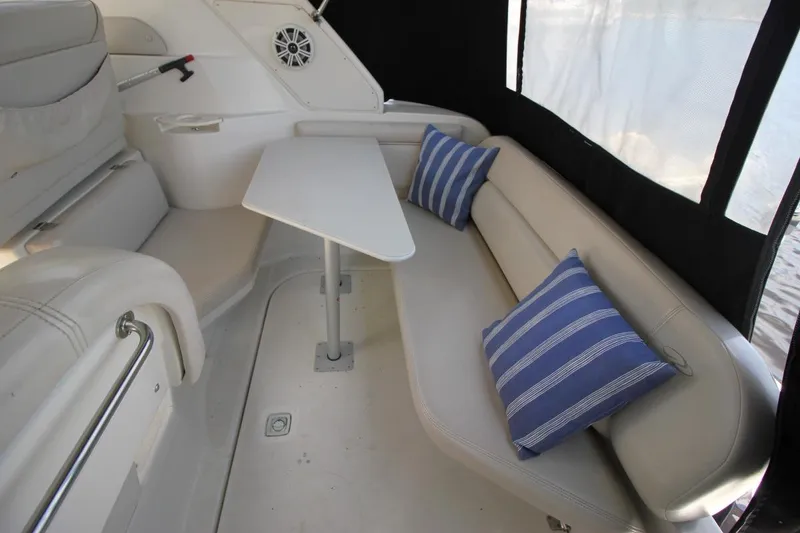 Slide: The Image of Interior of 2002 Regal Commodore 2860 boat with seating, table, and striped cushions. - 10