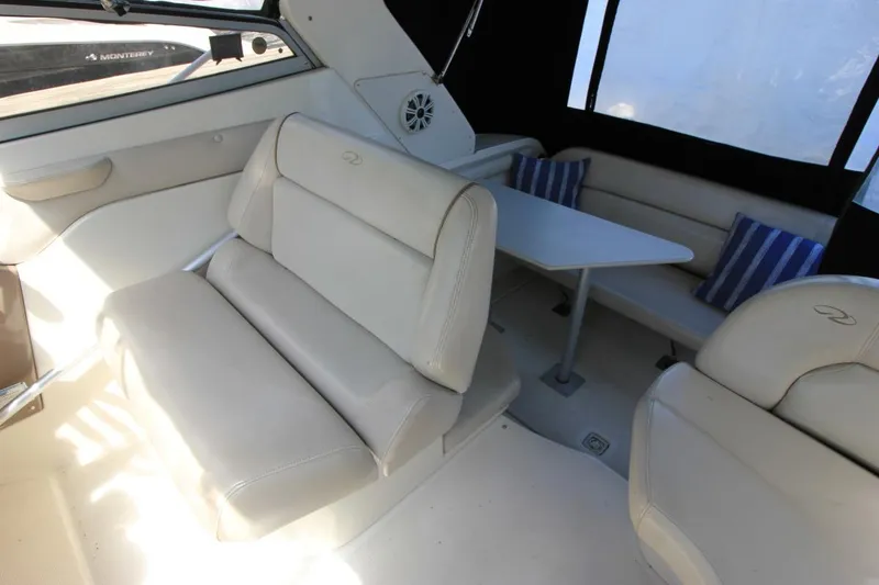 Slide: The Image of Interior of 2002 Regal Commodore 2860 boat with beige seating and striped cushions. - 12
