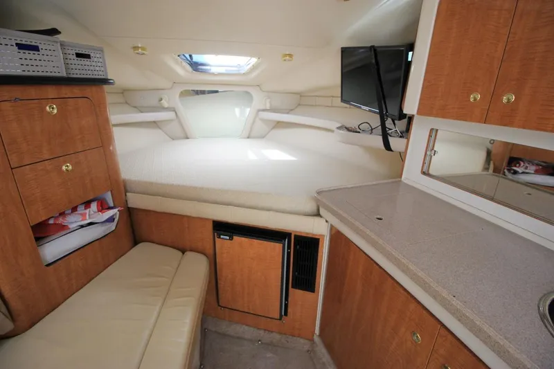 Slide: The Image of 2002 Regal Commodore 2860 cabin interior with bed, cabinets, and TV. - 19