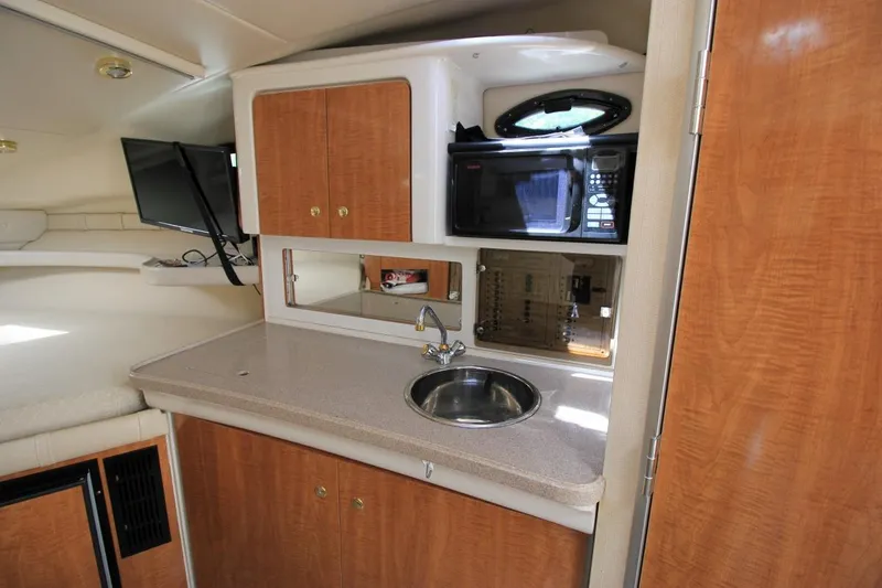 Slide: The Image of Interior of 2002 Regal Commodore 2860 boat with kitchenette, sink, and microwave. - 22