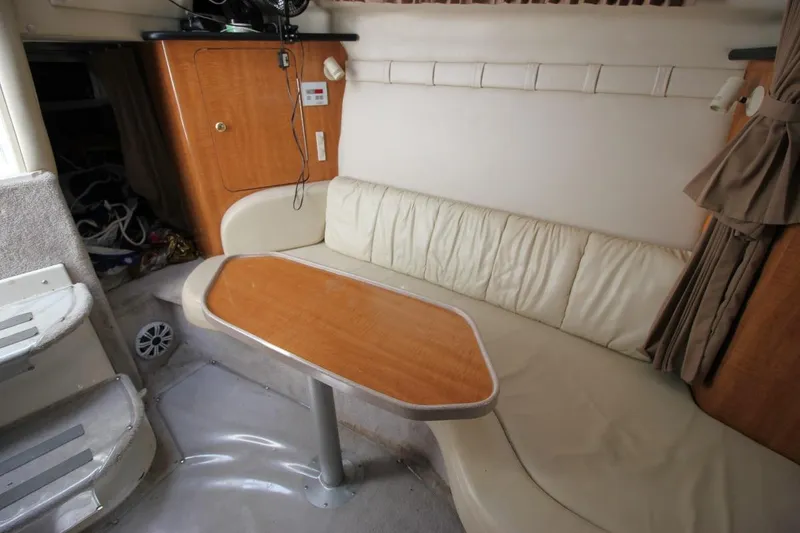 Slide: The Image of Interior of 2002 Regal Commodore 2860 boat with beige seating and wooden table. - 23