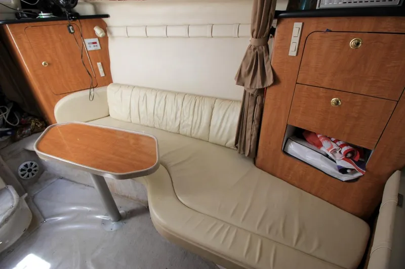 Slide: The Image of Interior of 2002 Regal Commodore 2860 boat with beige seating and wooden cabinetry. - 24