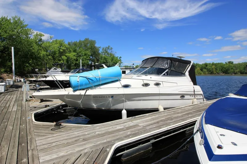 Slide: The Image of 2002 Regal Commodore 2860 boat docked at a marina, surrounded by trees and blue sky. - 3