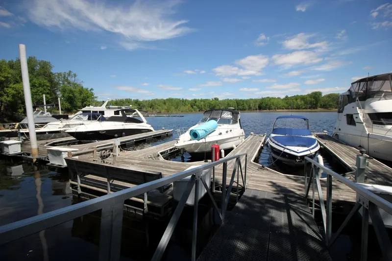Slide: The Image of Boats docked at a marina, featuring a 2002 Regal Commodore 2860 under a clear blue sky. - 4
