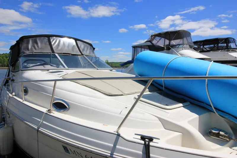 Slide: The Image of 2002 Regal Commodore 2860 boat docked with blue float, under clear sky. - 5