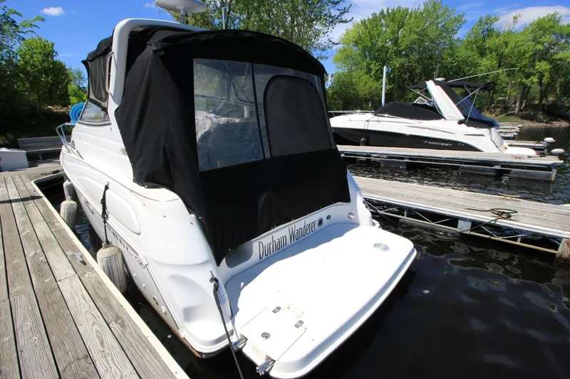 Slide: The Image of 2002 Regal Commodore 2860 boat docked, featuring black canopy and white hull. - 6