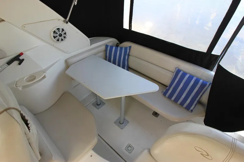 Slide: The Image of Interior of 2002 Regal Commodore 2860 boat with seating area and striped cushions. - 9