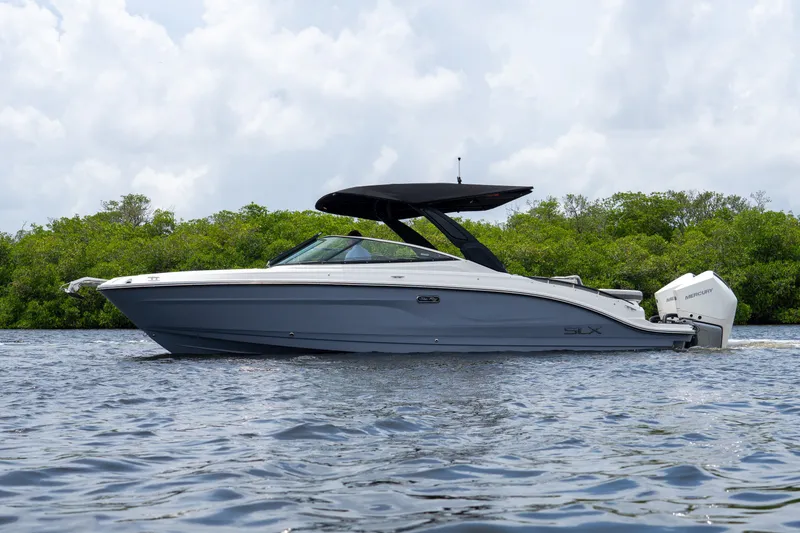 Slide: The Image of A sleek, modern motorboat with a black canopy cruising on calm waters. - 30