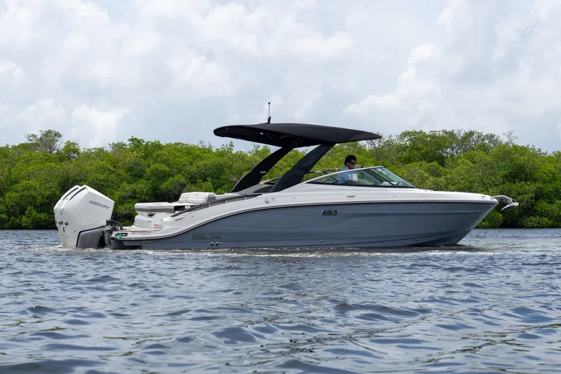 Slide: The Image of A 2027 Sea Ray SLX 280 Outboard cruising on calm waters, surrounded by lush greenery. - 2