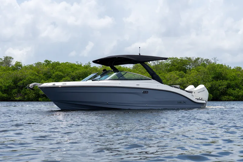 Slide: The Image of A sleek, modern motorboat on calm water, surrounded by lush greenery. It features a black canopy. - 3