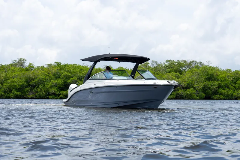 Slide: The Image of A 2027 Sea Ray SLX 280 Outboard cruising on calm waters, surrounded by lush greenery. - 37