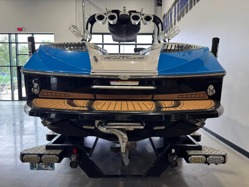 Slide: The Image of Rear view of a 2013 Nautique Super Air Nautique G25 boat in a showroom. - 7