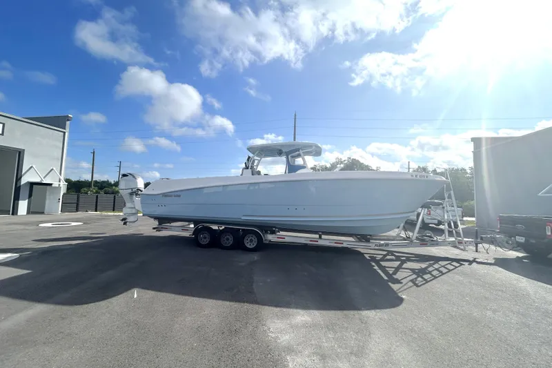 Slide: The Image of 2023 Twin Vee 340 GFX CC boat on trailer under clear blue sky. - 1