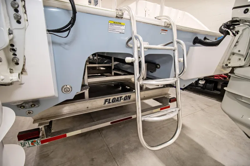 Slide: The Image of 2023 Twin Vee 340 GFX CC boat with ladder on trailer in garage. - 10