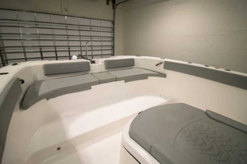 Slide: The Image of 2023 Twin Vee 340 GFX CC boat interior with gray seating in a garage setting. - 13