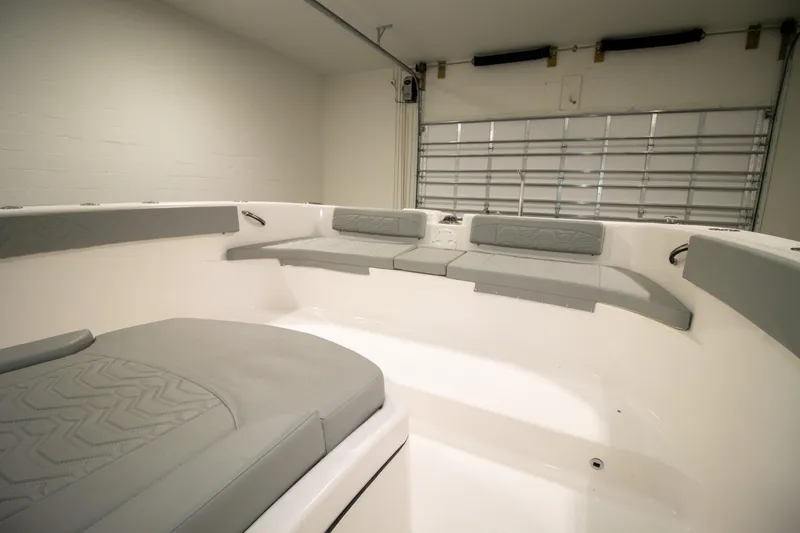 Slide: The Image of 2023 Twin Vee 340 GFX CC boat interior with sleek gray seating in a spacious garage. - 14