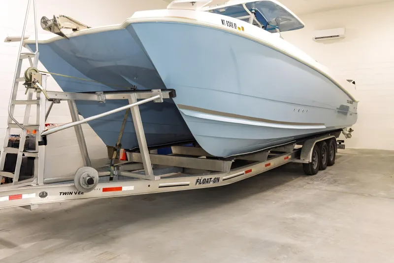 Slide: The Image of 2023 Twin Vee 340 GFX CC boat on trailer in indoor storage. - 2