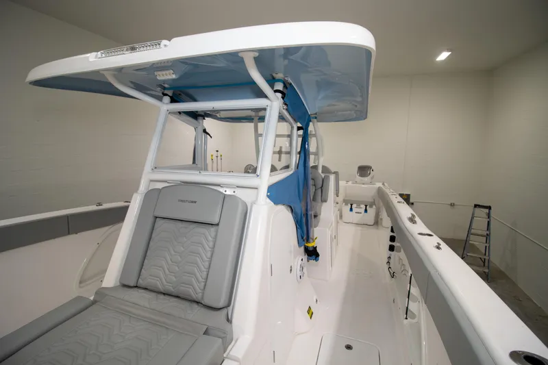 Slide: The Image of 2023 Twin Vee 340 GFX CC boat interior with seating and canopy in a showroom. - 20