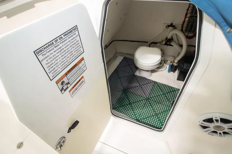 Slide: The Image of 2023 Twin Vee 340 GFX CC boat interior with marine toilet and warning labels. - 21