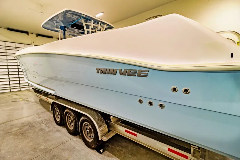 Slide: The Image of 2023 Twin Vee 340 GFX CC boat on trailer in garage setting. - 5