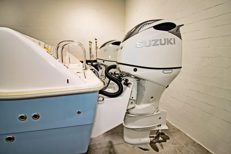 Slide: The Image of 2023 Twin Vee 340 GFX CC boat with dual Suzuki outboard motors in a garage. - 7