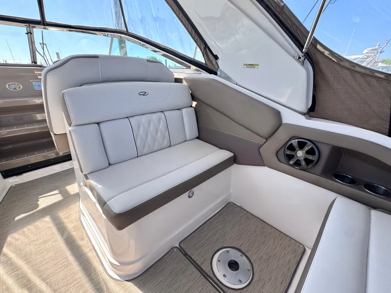 Slide: The Image of Interior of a 2018 Regal 28 Express boat with beige seating area. - 16