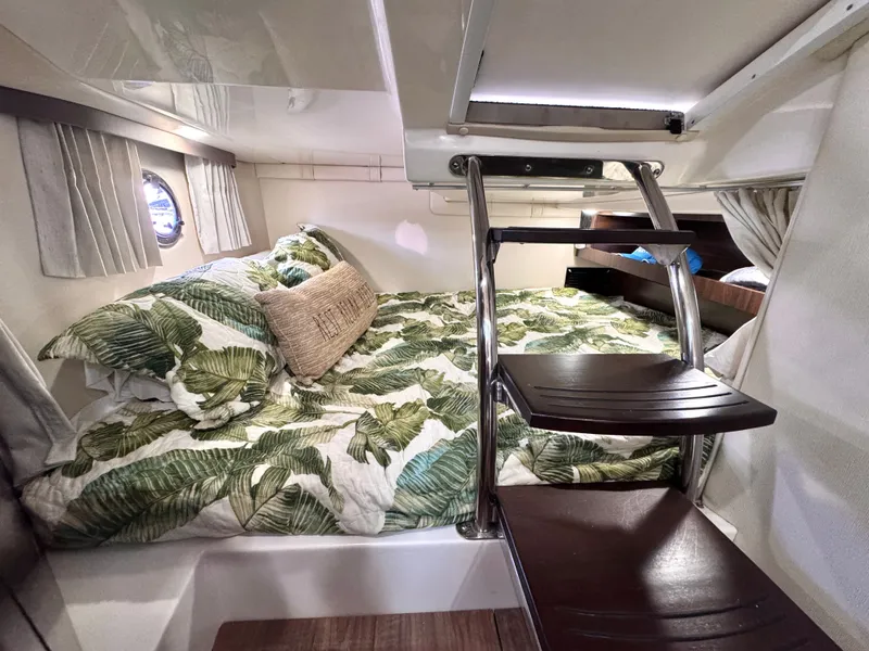 Slide: The Image of Interior of 2018 Regal 28 Express with cozy bed and leaf-patterned bedding. - 29