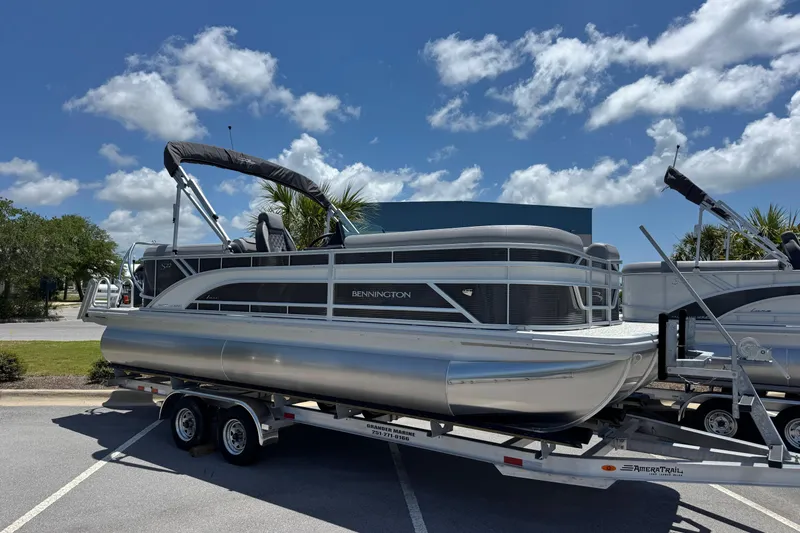 The Image of 2026 Bennington 22 SSR pontoon boat on trailer under blue sky. - 1