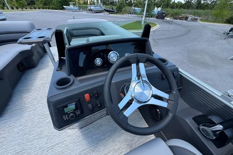Slide: The Image of Steering console of 2026 Bennington 22 SSR pontoon boat with modern controls and cup holders. - 9