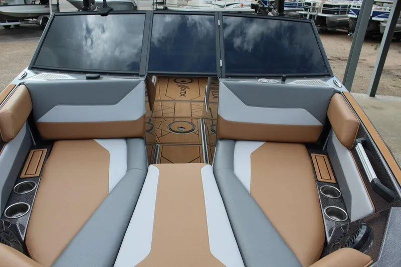 Slide: The Image of 2024 ATX Surf Boats 22 Type-S interior with tan and gray seating, cup holders, and sleek design. - 20