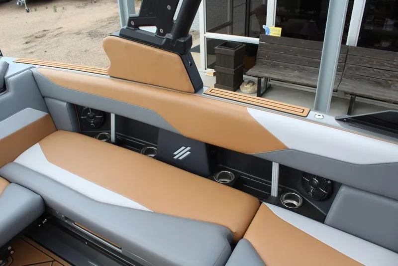 Slide: The Image of 2024 ATX Surf Boats 22 Type-S interior with tan and gray seating, cup holders, and speakers. - 22