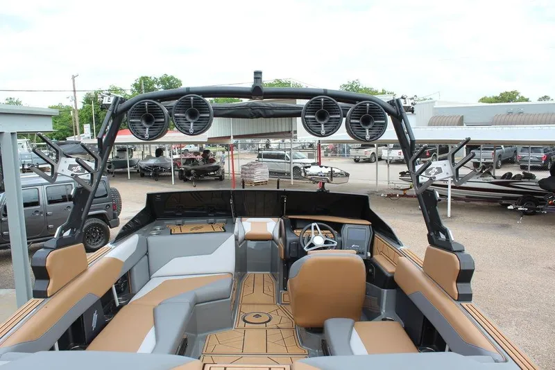 Slide: The Image of 2024 ATX Surf Boats 22 Type-S interior with speakers and seating, parked outdoors. - 25