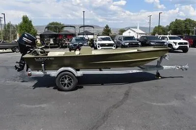 The Image of 2025 Lowe L1652MT Jon boat on trailer, parked in lot with cars and trees. - 0