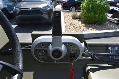 Slide: The Image of 2025 Lowe L1652MT Jon boat control panel with throttle lever in a parking lot. - 14