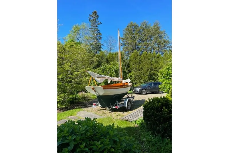 Slide: The Image of Herreshoff 12 1/2 sailboat from 2003 on a trailer in a lush garden setting. - 3