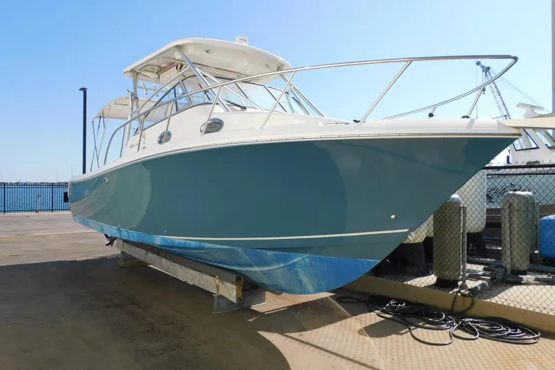 The Image of 2012 Sailfish 30-06 Express boat on dry dock, blue hull, marina background. - 1