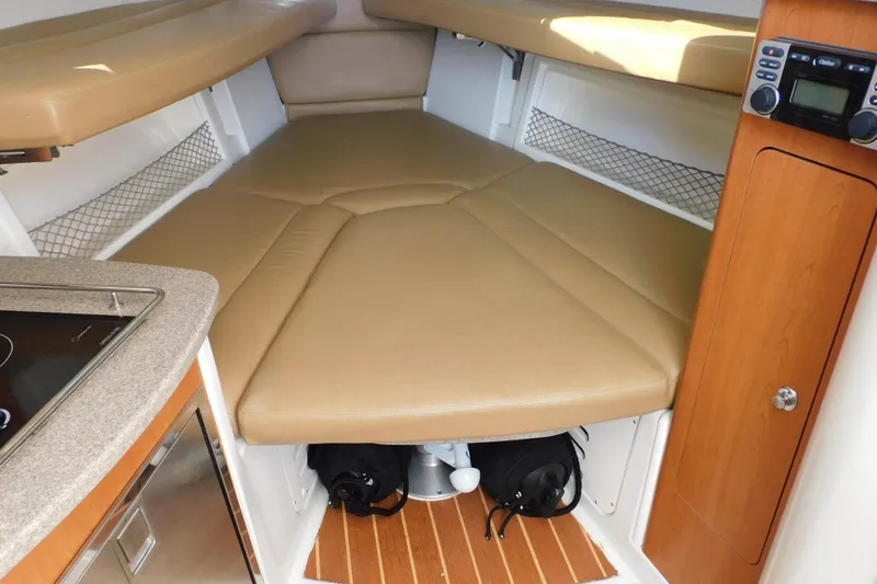 Slide: The Image of Interior cabin of 2012 Sailfish 30-06 Express boat with beige cushions and wooden accents. - 15