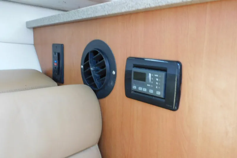 Slide: The Image of Interior of 2012 Sailfish 30-06 Express with control panel and vent on wooden paneling. - 18