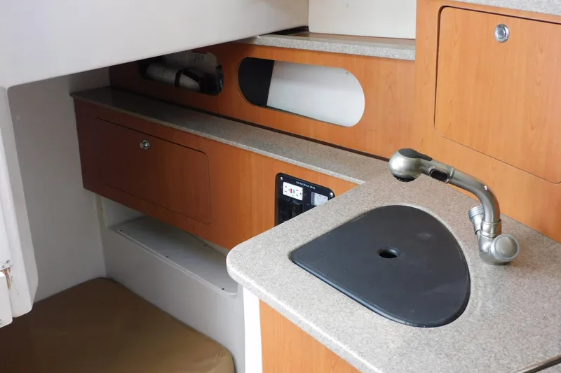Slide: The Image of 2012 Sailfish 30-06 Express boat interior with sink and wooden cabinetry. - 21