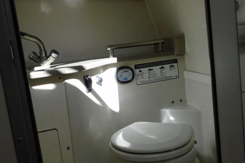 Slide: The Image of Compact bathroom in 2012 Sailfish 30-06 Express boat, featuring sink and toilet. - 23