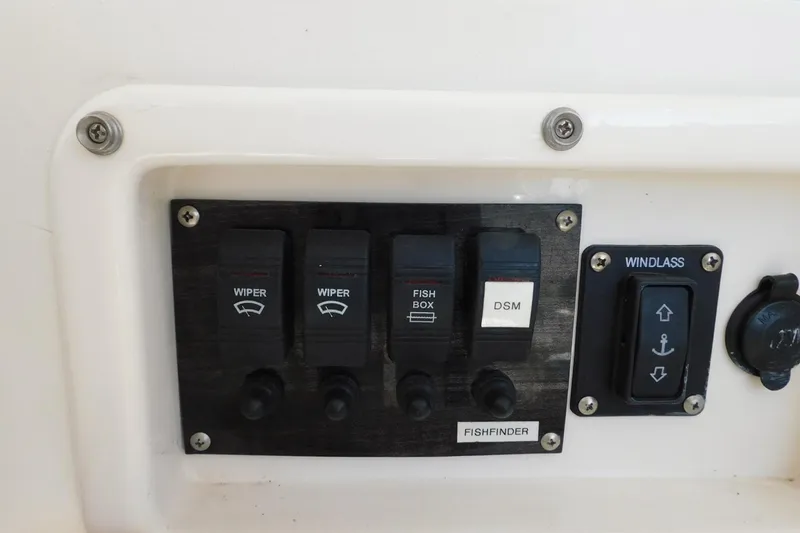 Slide: The Image of Control panel on a 2012 Sailfish 30-06 Express boat with switches for wipers, fish box, DSM, and windlass. - 5